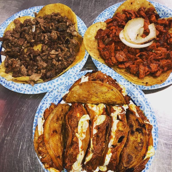 Three plates of tacos, including steak, al pastor with onion, and cheesy birria tacos.